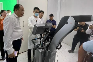 PGS-TS Tăng Chí Thượng, Giám đốc Sở Y tế TPHCM đang theo dõi kết quả trên máy chụp X-Quang AI tại Trung tâm Y tế xã đảo Thạnh An