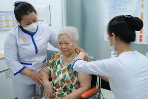 Nhân viên y tế tiêm vaccine zona thần kinh cho người cao tuổi