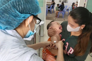 Nhân viên Trung tâm Y tế quận Tân Bình đang tiêm vaccine tiêm chủng mở rộng cho trẻ