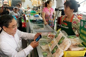 Ông Nguyễn Ngọc Hòa, Phó Giám đốc Sở Công thương TPHCM kiểm tra thịt gà truy xuất tại chợ Bến Thành