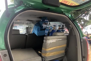 Nhân viên y tế đang lắp bình oxy trên xe taxi Mai Linh