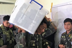 Binh sĩ mang thùng chứa 52,2 triệu peso (1,06 triệu USD) phát hiện trong tầng hầm một ngôi nhà phiến quân Maute chiếm ở TP Marawi, Philippines, ngày 6-6-2017. Ảnh: REUTERS