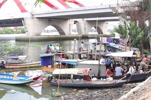 Xóm chài với vài ba hộ gia đình nằm trên sông Sài Gòn, đoạn giữa hai cầu Bình Lợi mới và cũ