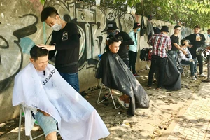 Tiệm cắt tóc miễn phí trên vỉa hè đường Phạm Văn Đồng