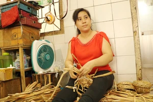 Chị Nguyễn Thúy Hà với mẫu sáng tạo giỏ bằng sợi lục bình mang lại hiệu quả cao cho Hợp tác xã Mây tre lá Ba Nhất. Ảnh: MAI HOA