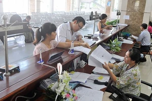 Giải quyết hồ sơ thuế cho doanh nghiệp tại Cục Thuế TPHCM Ảnh: CAO THĂNG
