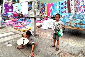 Trẻ em ăn xin trên đường phố, ở quận 5, TPHCM. Ảnh: TUẤN VŨ