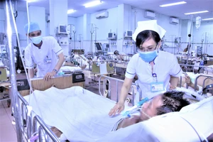 Điều dưỡng Trần Thị Thu An chăm sóc cho bệnh nhân V. tại Khoa Hồi sức cấp cứu - Chống độc, BV Phạm Ngọc Thạch. Ảnh: QUANG HUY