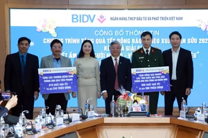 Đại diện BIDV trao bảng tượng trưng cho các đơn vị để tặng quà Tết cho người nghèo 