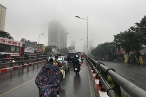 Sương mù kèm mưa phùn ẩm ướt bao phủ Hà Nội ngày 3-2. Ảnh: VĂN PHÚC