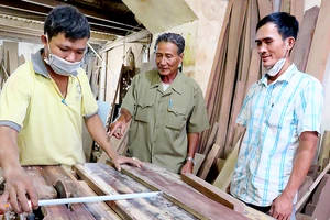 Xưởng gỗ của ông Tạ Ngọc Quang (đứng giữa) tạo công ăn việc làm cho nhiều con em thương bệnh binh 