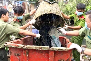 Cán bộ - chiến sĩ trẻ Công an quận 8 tham gia dọn rác trên rạch trong chiến dịch Hành quân xanh 2018. Ảnh: TUẤN VŨ