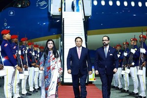 政府总理范明政偕夫人和越南高级代表抵达首都圣多明各美洲国际机场，开始进行正式访问。（图：越通社）