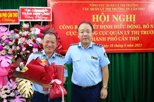Ông Trần Hữu Linh (phải), Tổng Cục trưởng Cục QLTT, trao quyết định điều động, bổ nhiệm cho ông Nguyễn Hùng Em