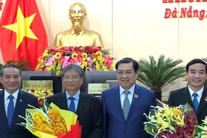 Bí thư Thành ủy Đà Nẵng Trương Quang Nghĩa tặng hoa chúc mừng cho ông Lê Trung Chinh (bìa phải) vừa được bầu vào chức danh Phó Chủ tịch UBND TP Đà Nẵng