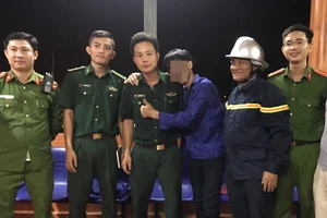 Trần Văn B. (áo xanh, giữa) bị ngáo đá, nhảy xuống vực sâu trên bán đảo Sơn Trà được các lực lượng cứu hộ cứu nạn tìm thấy