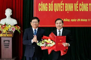 Ông Võ Công Trí, Phó Bí thư Thường trực Thành ủy Đà Nẵng trao quyết định và tặng hoa chúc mừng nhà báo Nguyễn Đức Nam