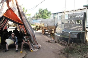 Người dân dựng lều trước cổng Nhà máy sản xuất sản phẩm ván và Veneer gỗ để yêu cầu nhà máy khắc phục việc gây ô nhiễm môi trường. Ảnh CÔNG HOAN.
