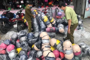 Lực lượng chức năng đột kích cửa hàng kinh doanh mũ bảo hiểm giả danh "Nón Sơn" tại Đà Nẵng. Ảnh do văn phòng Bộ Công thương cung cấp