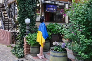 Ann háo hức chờ đợi trận đấu bắt đầu với Romania, vô phủ trên người lá cờ Ukraine.