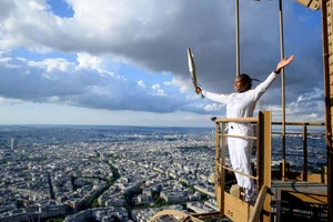 Võ sĩ Judo Clarisse Agbegnenou cầm Ngọn đuốc Olympic trên Tháp Eiffel như một phần của lễ rước đuốc Olympic ở Paris, trước Thế vận hội Olympic Paris 2024.