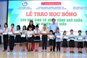 Đại diện Hội Nhà báo tỉnh Bình Dương và Ngân hàng Agribank trao học bổng cho học sinh Tiểu học 