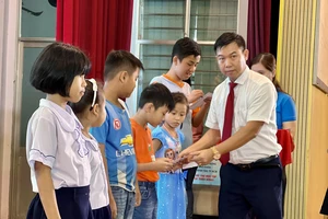 Ông Nguyễn Văn Nhì, Phó Giám đốc Ngân hàng Agribank, chi nhánh KCN Tân Tạo trao học bổng cho các em học sinh. Ảnh: CTV