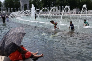 Khách du lịch đến đài phun nước ở Washington D.C tránh nắng. Nguồn: Getty Images