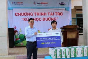 Ông Vũ Quang Sáng, Chủ tịch Công đoàn EVNGENCO3 (ảnh trái) trao biểu trưng tài trợ cho Trường Tiểu học Vĩnh Tiến.