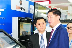 Phó Chủ tịch UBND TPHCM Trần Vĩnh Tuyến (giữa) tham quan gian hàng trưng bày của Công ty Điện tử Cây Tre Việt