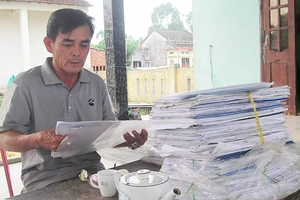 Ngư dân Trần Văn Thanh với chồng hồ sơ gần 3 năm mang gửi các ngân hàng nhưng đều bị từ chối cho vay