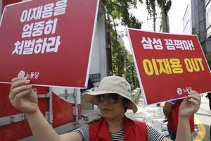 Người biểu tình giương biểu ngữ phản đối Phó Chủ tịch Samsung Electronics Lee Jae-yong" trước Tòa án Trung tâm Seoul ngày 25-8-2017. Ảnh: AP