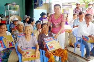Bà Tâm (đứng) trao quà tặng người nghèo