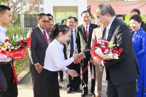 Học sinh Trường PTTH Hữu nghị Viêng Chăn - TPHCM tặng hoa, chào đón đoàn. Ảnh: KIỀU PHONG