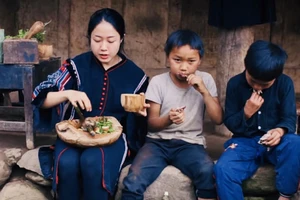 Vương Anh cùng trẻ em bản địa thưởng thức món bồ câu nướng vừa nấu tại Tủa Châu - Điện Biên (Ảnh cắt từ clip)
