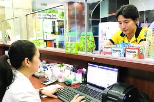 Nhân viên một nhà thuốc ở quận 7, TPHCM, truy cập dữ liệu thuốc qua mạng. Ảnh: Hoàng Hùng