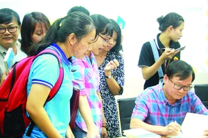 Nhà văn Nguyễn Nhật Ánh ký tên lên sách tặng độc giả trẻ - đối tượng tiềm năng của ngành xuất bản hiện nay