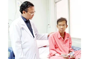 Bác sĩ Nguyễn Thái An thăm hỏi sức khỏe một bệnh nhân người Campuchia. Ảnh: NVCC