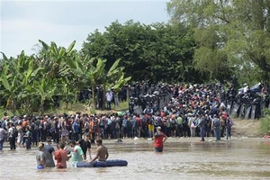 Người di cư băng qua sông Suchiate từ Ciudad Tecun Uman (Guatemala) để tới Ciudad Hidalgo (Mexico) trong hành trình đến Mỹ. Ảnh: TTXVN