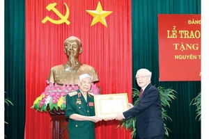 Tổng Bí thư, Chủ tịch nước Nguyễn Phú Trọng, Bí thư Quân ủy Trung ương trao Huy hiệu 70 năm tuổi Đảng tặng đồng chí Lê Khả Phiêu. Ảnh: TTXVN