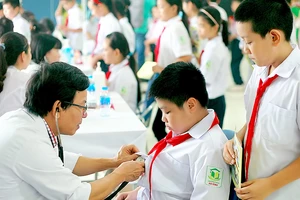 Bác sĩ khám bệnh cho học sinh trong vùng bị ảnh hưởng của vụ cháy Công ty Rạng Đông