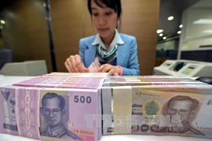 Kiểm tiền baht của Thái Lan tại ngân hàng Krung Thai ở Bangkok. Ảnh: AFP/TTXVN