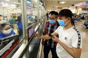 Hành khách khai báo y tế tại Bến xe miền Đông chiều 27-3. Ảnh: CAO THĂNG