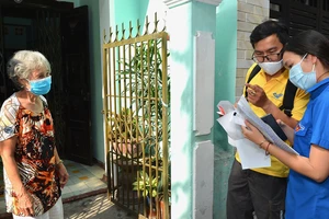 Bưu tá và chuyên viên UBND phường Tân Định (quận 1, TPHCM) tới nhà chi trả chế độ ưu đãi người có công với cách mạng. Ảnh: VIỆT DŨNG