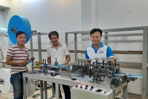 PGS.TS Nguyễn Hữu Lộc (giữa) và TS Nguyễn Thanh Hải (phải) bên máy tạo thân khẩu trang y tế.
