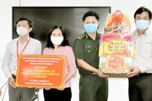 Đồng chí Nguyễn Thị Thu Hoài (thứ 3 từ trái sang) tặng quà Ban giám đốc Trung tâm Kiểm soát bệnh tật TPHCM