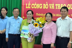 Đồng chí Võ Thị Dung trao quyết định và tặng hoa chúc mừng đồng chí Nguyễn Thanh Xuân. Ảnh: THÁI PHƯƠNG