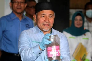 Bộ trưởng Nước và Môi trường Malaysia Tuan Ibrahim Tuan Man cầm trên tay mẫu bụi lò thép độc hại trong các container tại Cảng Tanjung Pelepas ngày 19-7. Nguồn: thestar.com.my