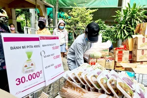 Chọn mua nhu yếu phẩm tại điểm bán dã chiến do Công ty TNHH Aeon Việt Nam tổ chức. Ảnh: NGỌC HIỂN