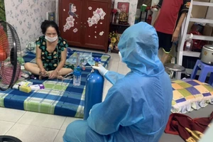 Một trường hợp F0 ở quận Bình Tân được hướng dẫn sử dụng bình oxy. Ảnh: MINH NGHĨA